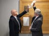 Brooks Campbell, left, and Jim Richards, the president of the SAU 8 board of education, unveil Edward Brooks' plaque at Concord High School's new Wall of Fame.