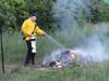 A pile of debris near a homeless camp burns on June 29 near Market Basket on the north side of Storrs Street. 