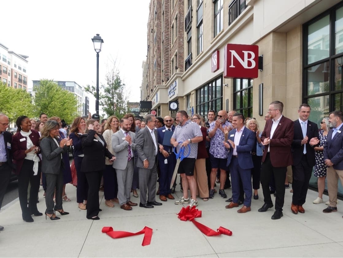 Joseph Campanelli, chairman, president, CEO of Needham Bank (center); Greg Hill of WEEI Boston’s Sports Original (center, holding scissors); along with employees and chamber members.