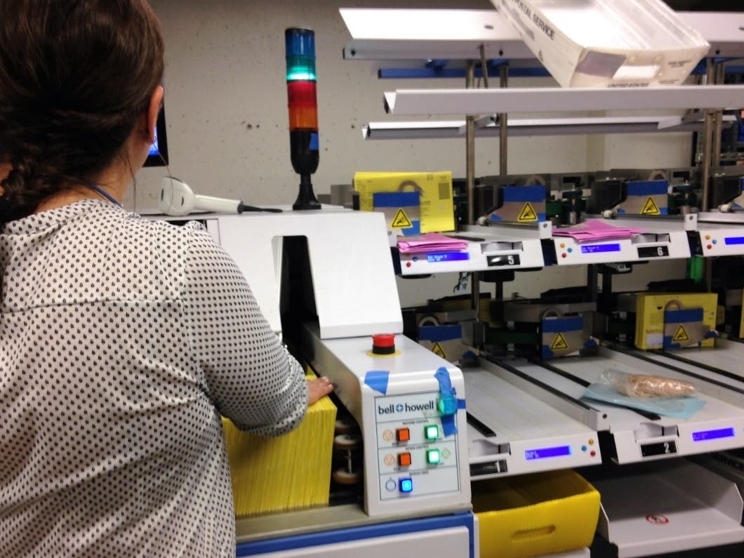 An Elections Department employee operates a new ballot sorter at the Civic Center.