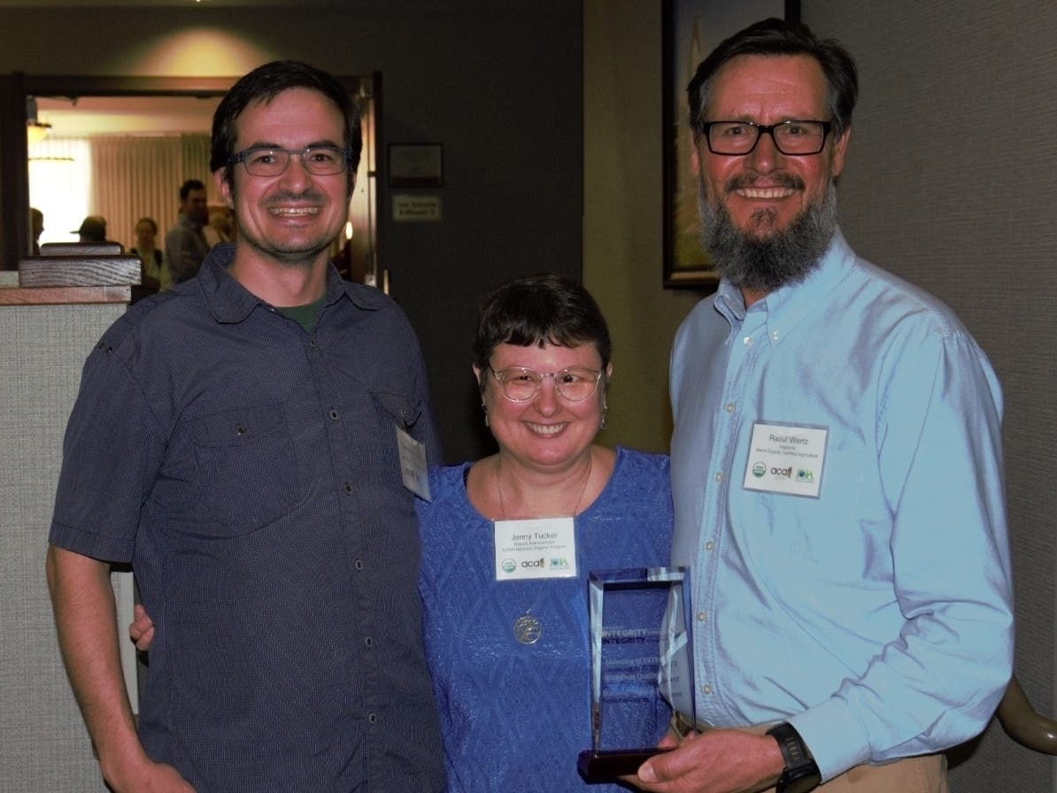 Marin County agricultural inspectors Chris Cook (left) and Raoul Wertz (right) accept an award from Jenny Tucker, deputy administrator for the National Organic Program.