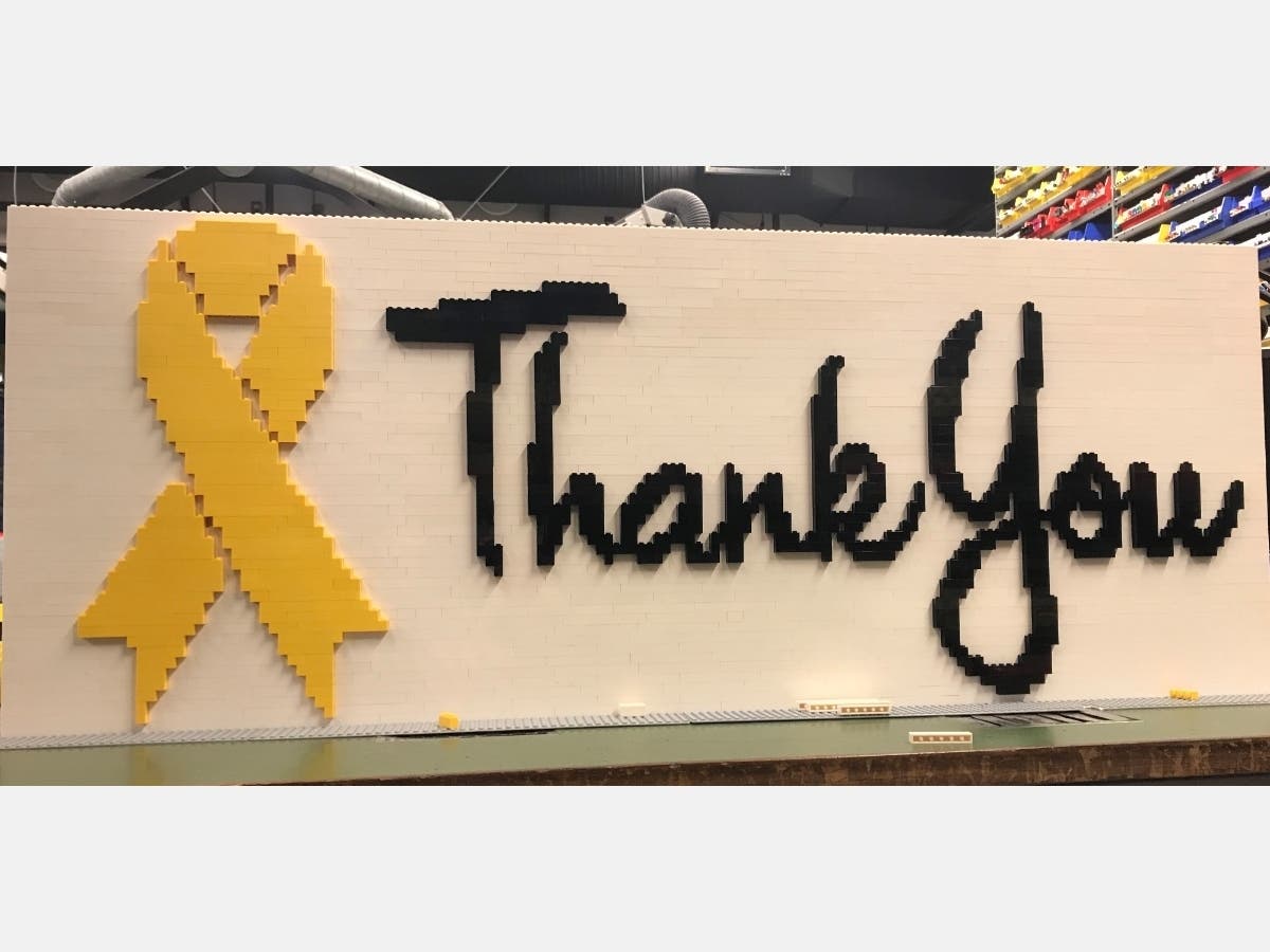 Model builder Tim Sams​ constructed the white mosaic with black script and a yellow ribbon, all created out of LEGO bricks​. 