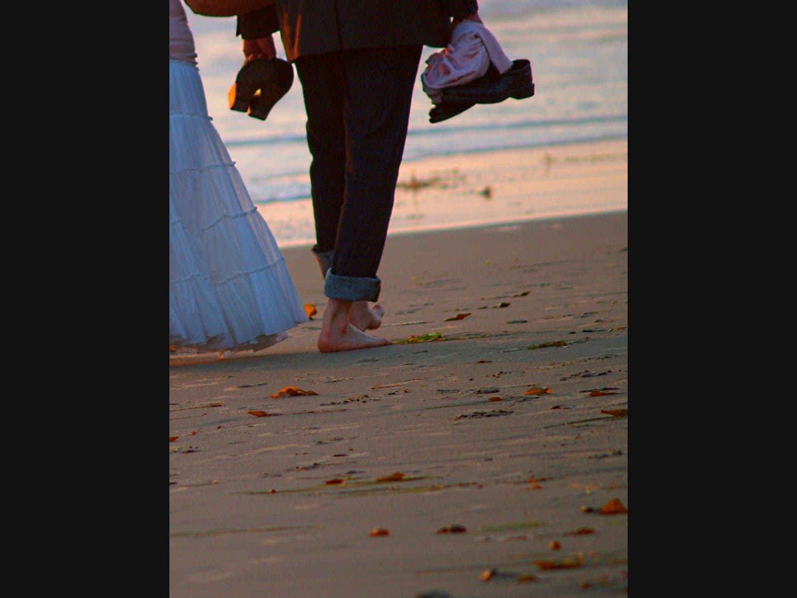 A couple walking on Moonlight State Beach​ in Encinitas