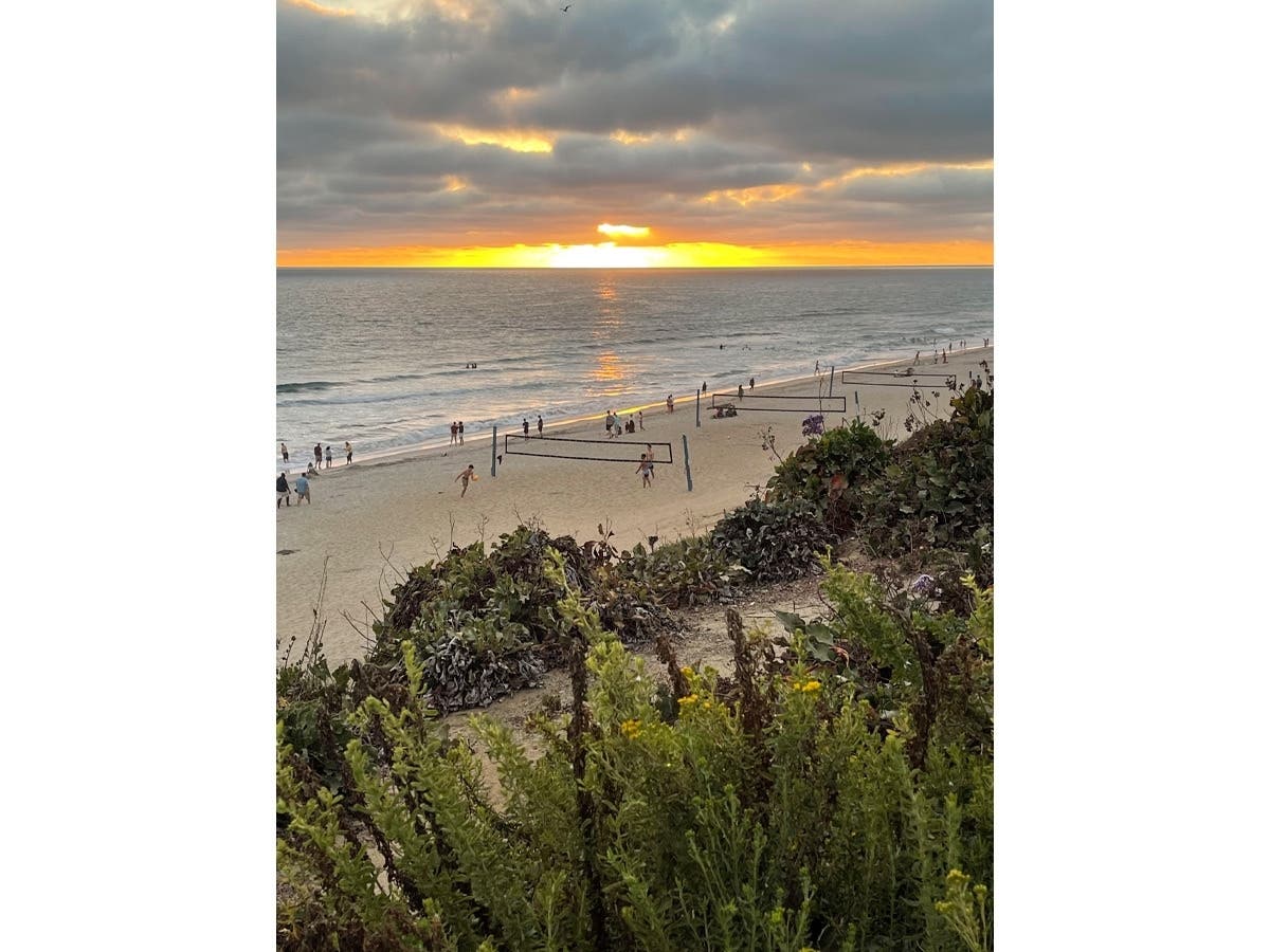 Beachgoers playing volleyball at Carlsbad State Beach​ in Carlsbad, California. 