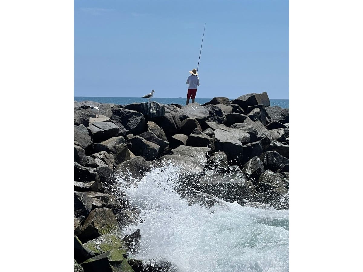 A man fishing in Carlsbad, California.
