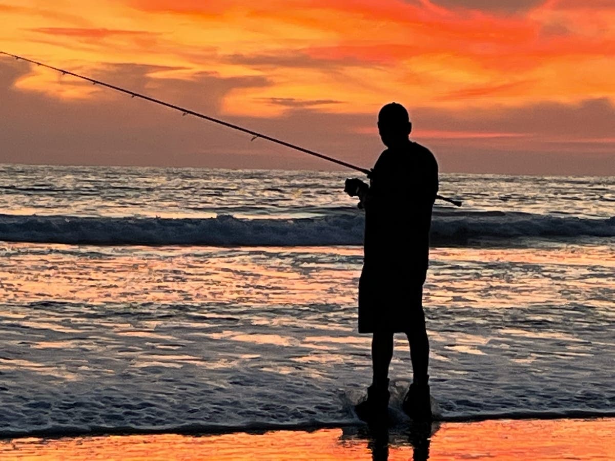 A man fishing at Torrey Pines State Beach in San Diego, California. 