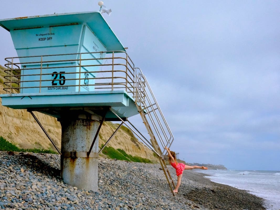 Avery Bell striking a pose at​ lifeguard tower 25 at South Carlsbad State Beach​.