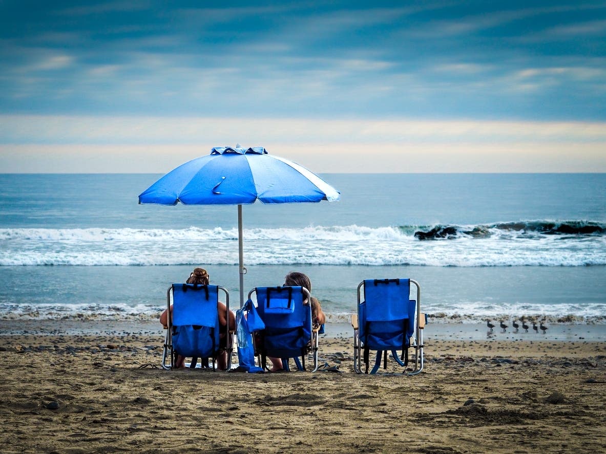 Beachgoers sitting on the beach in Oceanside, California. 