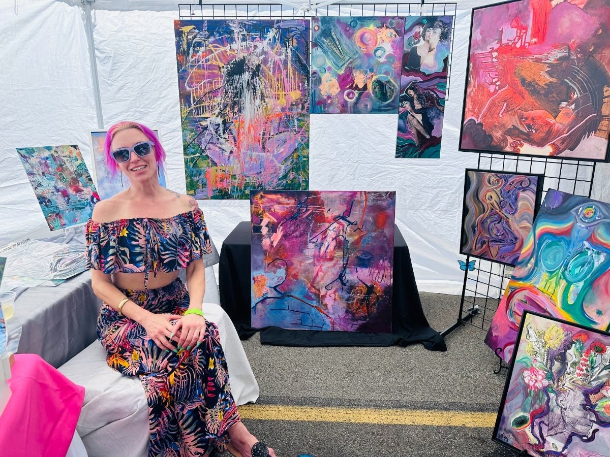 An artist with her artwork at ArtWalk Carlsbad in Carlsbad, California. 