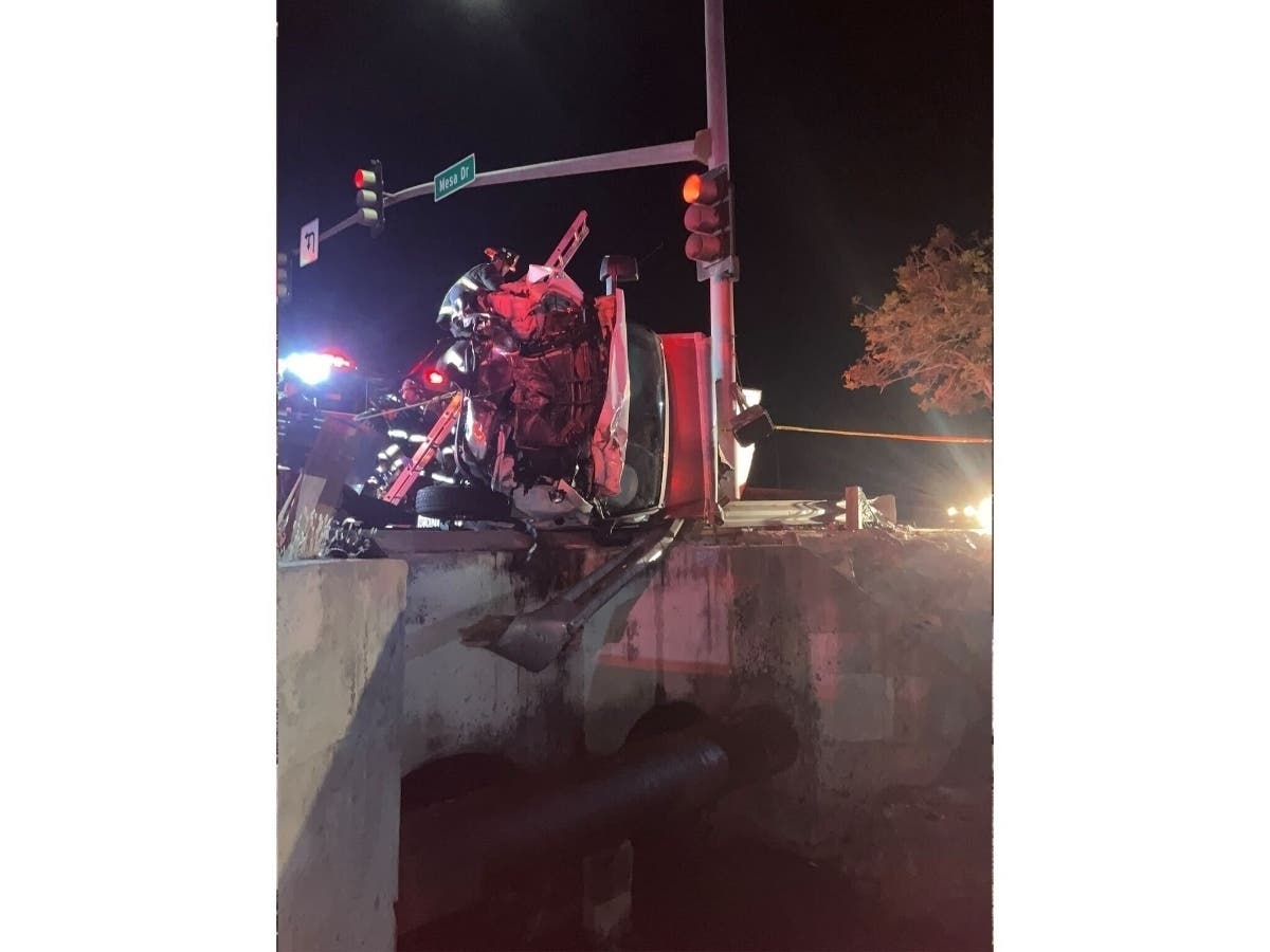 Two people were rescued after a vehicle overturned and partially teetered off a bridge in a two-car crash late Sunday, authorities said.