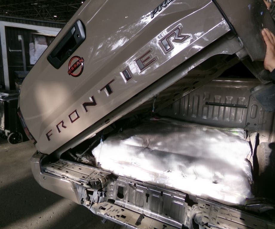 An imaging system scan and a canine team indicated the presence of drugs in a non-factory compartment in the truck bed.