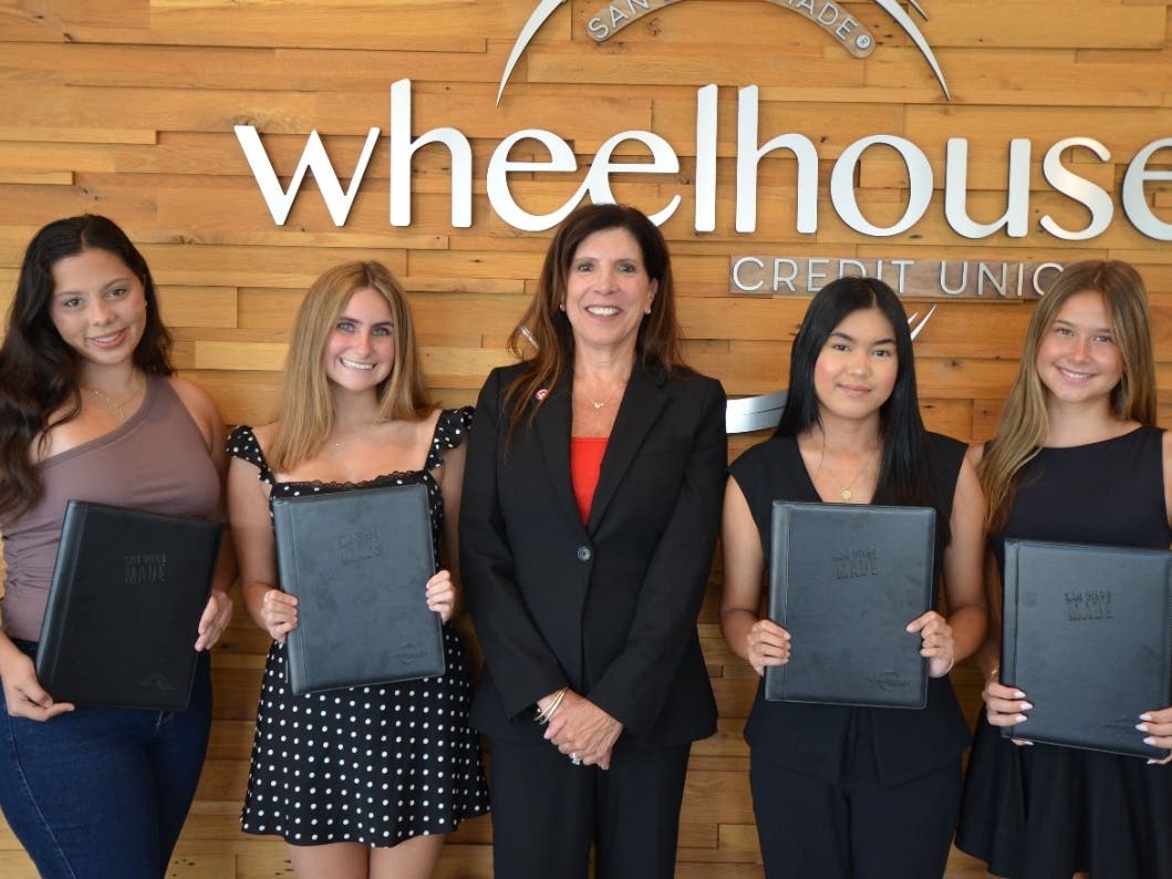 Wheelhouse Credit Union President and CEO Lisa Paul-Hill (center) presents Badge of Honor Scholarships to (L-R) Sydney Harris, Lila Hand, Kyra Imperial and Avery Wahl during a scholarship presentation ceremony at Wheelhouse Credit Union.