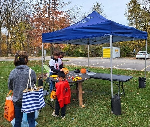 Student volunteer preparing one of the games for the next participant at Halloween Happening, 2022