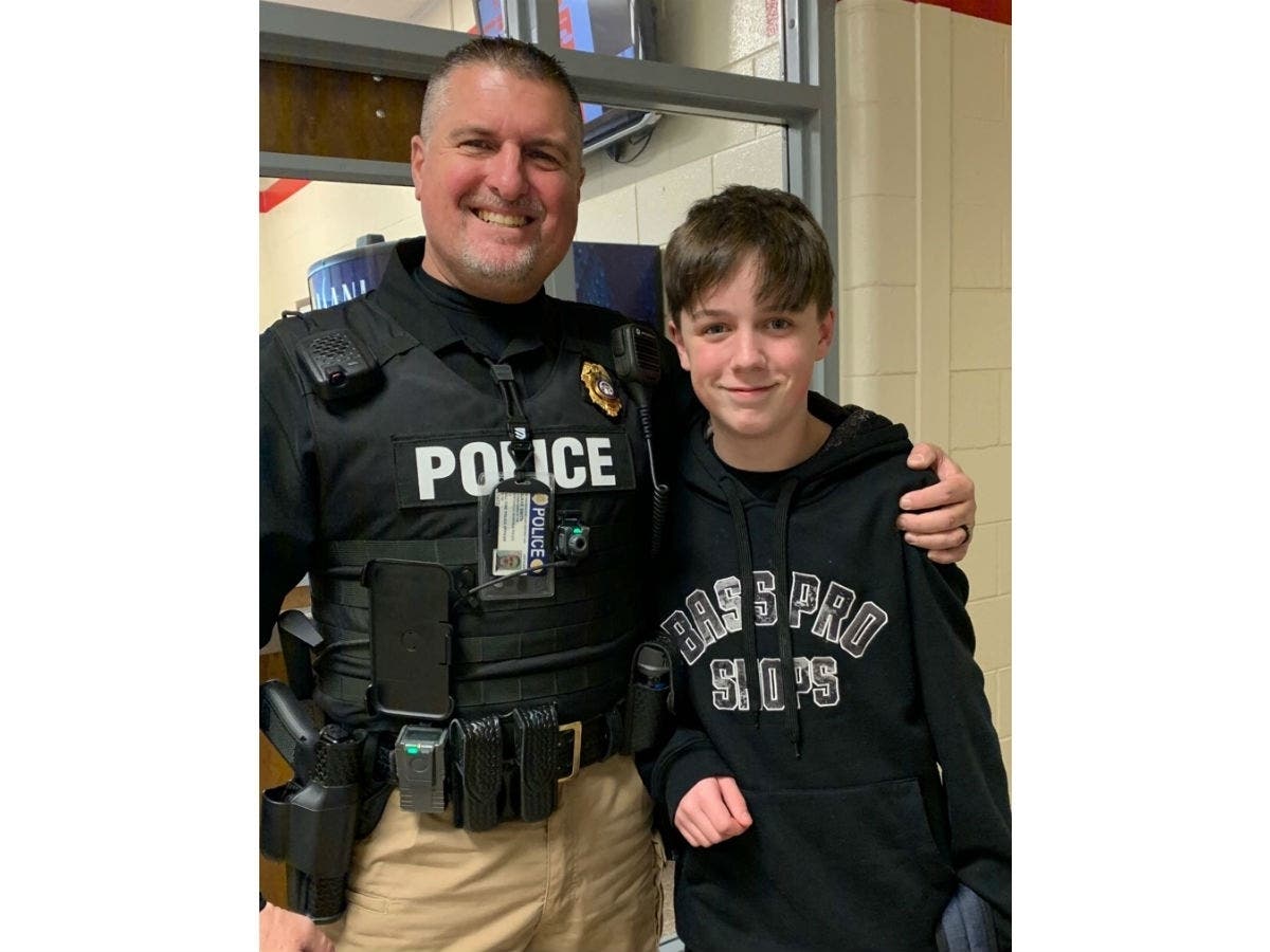 School Resource Officer Duane Smith takes a photo with Ethan Hamrick, whom he saved from choking earlier this week.