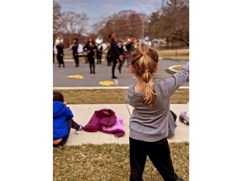 Kinsey Disher, a student in Georgetown Hill's pre-K program, imitates members of the Bowie State Sensations color guard team during a recent performance.