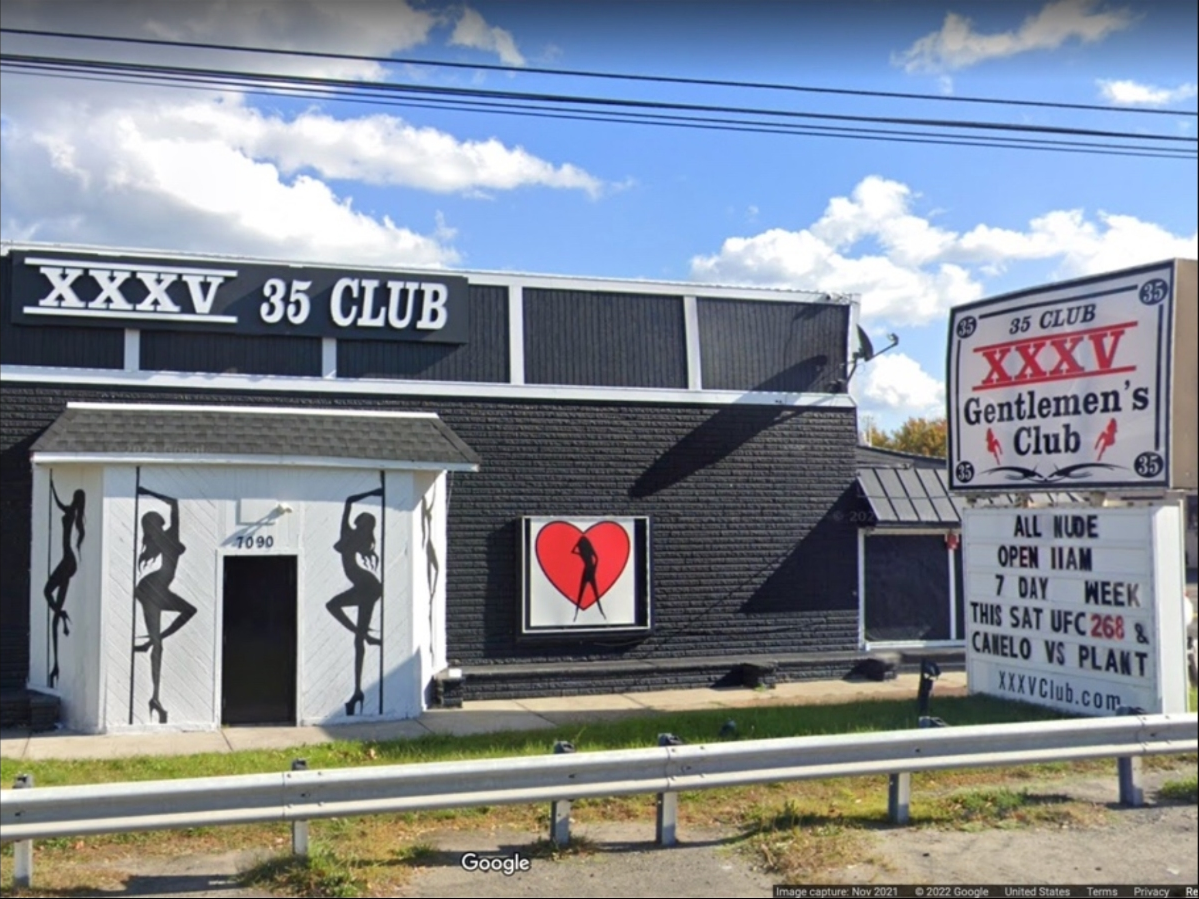 The wife of a Sayreville strip club owner facing prostitution and racketeering charges was handcuffed for several hours while barely clothed as multiple police officers arrested her husband and searched her home, according to a new lawsuit.