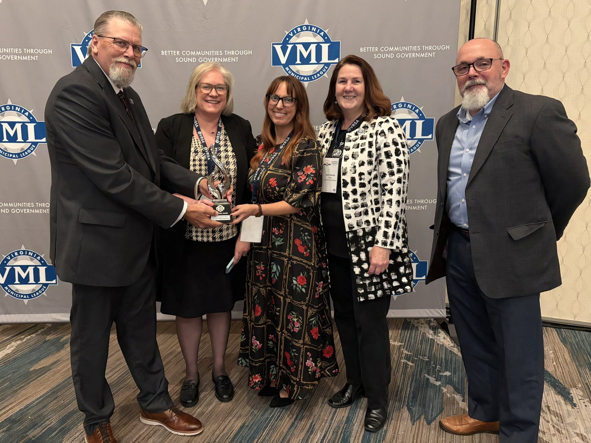 Virginia Municipal League (VML) President and Town of Amherst Mayor Dwayne Tuggle presents the 2026 Innovation Award in Communications to City of Fredericksburg officials.