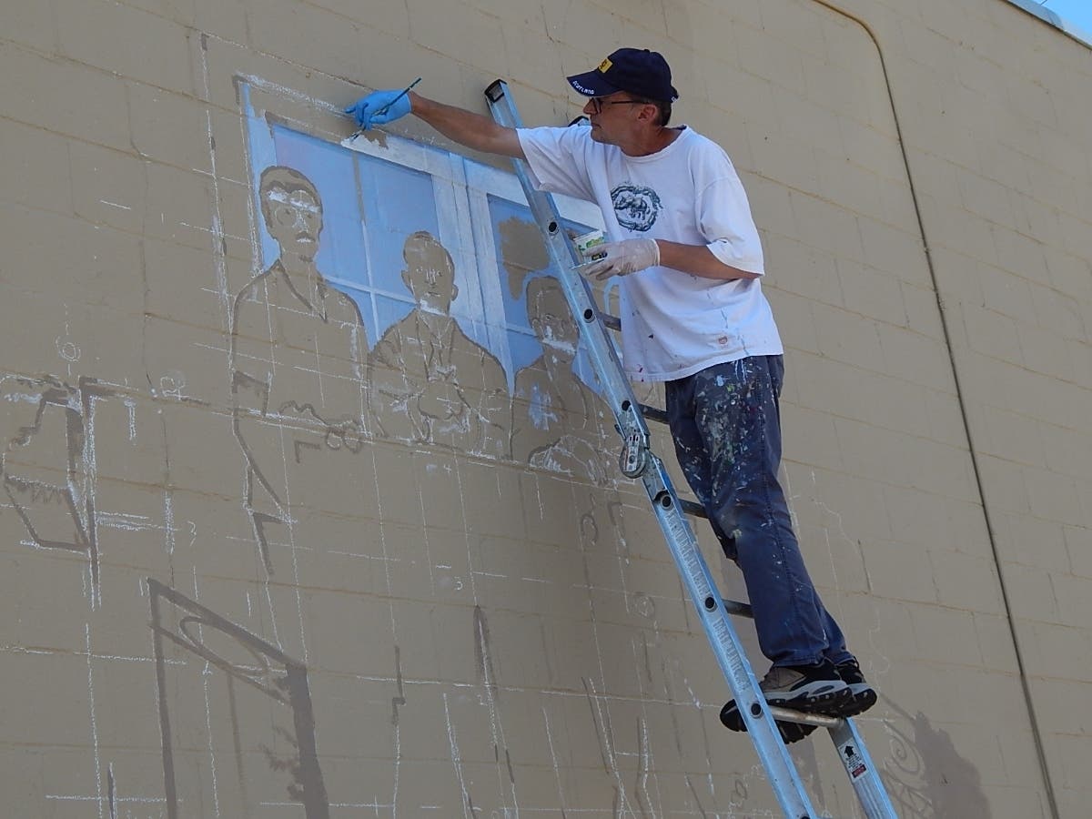 Muralist Jack Pabis is painting a window along the side of the Main Street Tower in Bel Air.