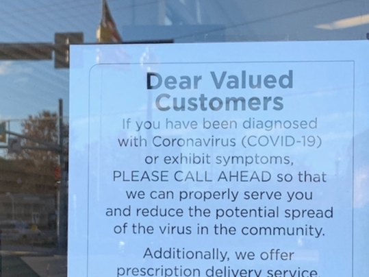 A sign at a pharmacy in Baltimore County advises people with the coronavirus to call ahead.