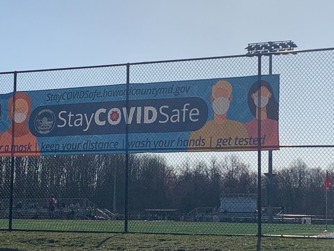 A banner encourages people to get tested for the coronavirus, wear a mask and keep their distance to prevent the spread of the virus. It is posted at Rockburn Park in Howard County, which is one of 14 jurisdictions in Maryland in the "red zone."
