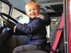 This youngster is thrilled to play pretend firefighter as he takes the wheel of a fire truck at the third annual Community Day at the Golden's Bridge Fire Department.