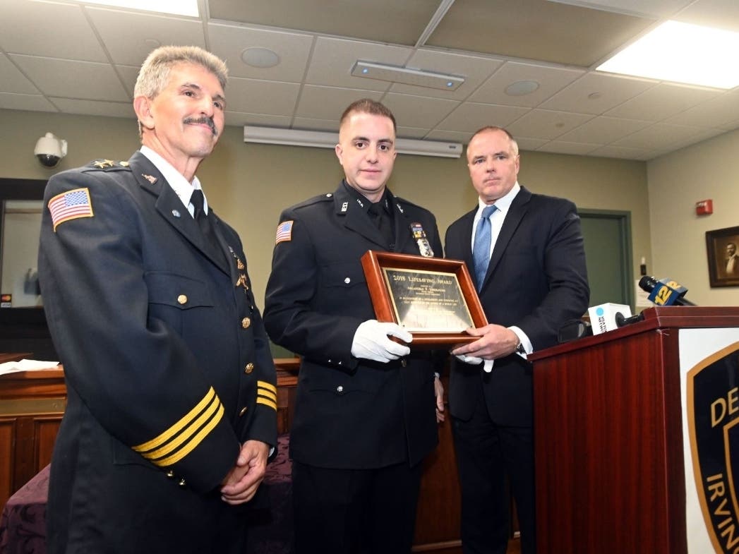 Irvington Police Officer Arcangelo F. Liberatore, center, rescued a child being attacked by a coyote.