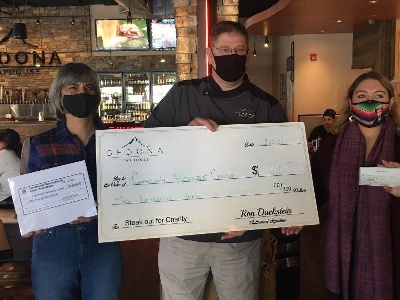 LM Lion Diane Oldham, Sedona's Bill Jablonski and Community Resource Center’s (and LM Lion) Jirandy Martinez with checks to help people avoid eviction.