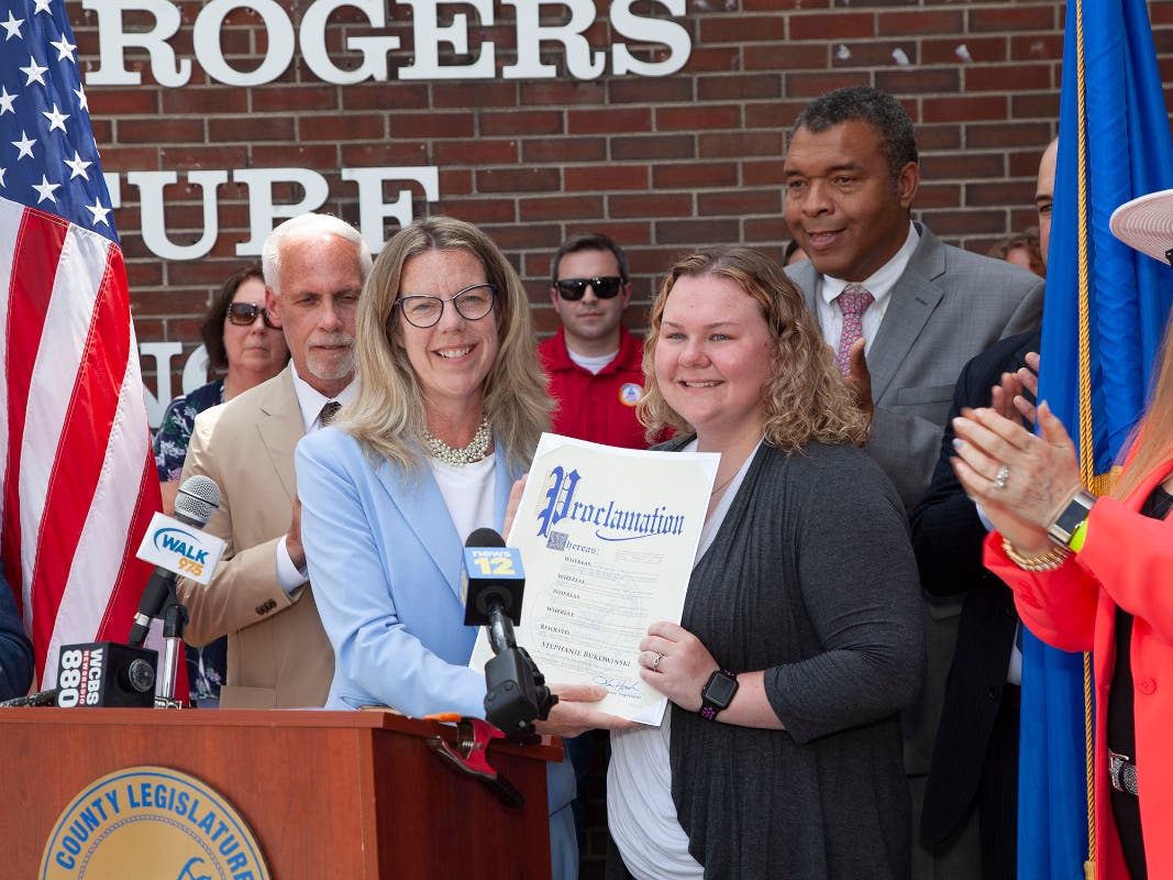 Suffolk County Legislators Kevin J. McCaffrey, William Spencer and Susan A. Berland join Deputy Presiding Officer Kara Hahn in honoring Emergency Dispatcher Stephanie Bukowinski for her professionalism during a June 1, 2021 active labor emergency call.