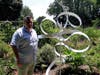 Artist Justin Carafotes with his sculpture "Nature Bath" at Ward Acres Community Garden.