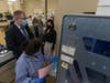 (From top left) Oleksandr Serhiienko, Nataliia Mizynets and Snizhana Mykytyn observe as Vintu Patel demonstrates use of an automated blood typing system at Elmhurst Hospital.
