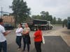 Michael Tadin Jr. (left) speaks to neighbors as a truck leaves the MAT Asphalt property.