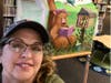 Local muralist Jill Roberts poses with the tent she painted for the Anza Valley Community Library's Summer Reading Program.