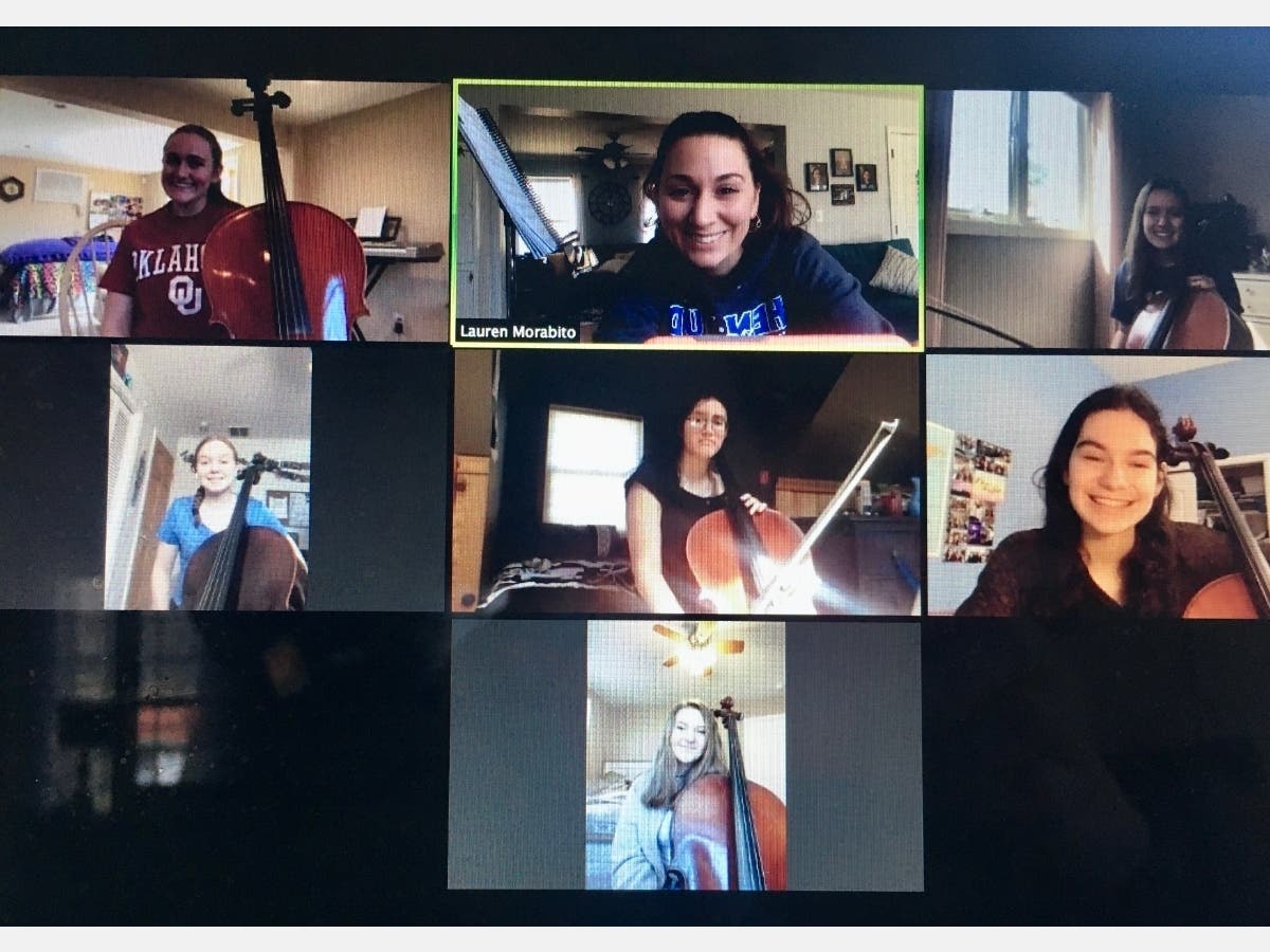 Orchestra director Lauren Morabito (top row, center) works with cello students.