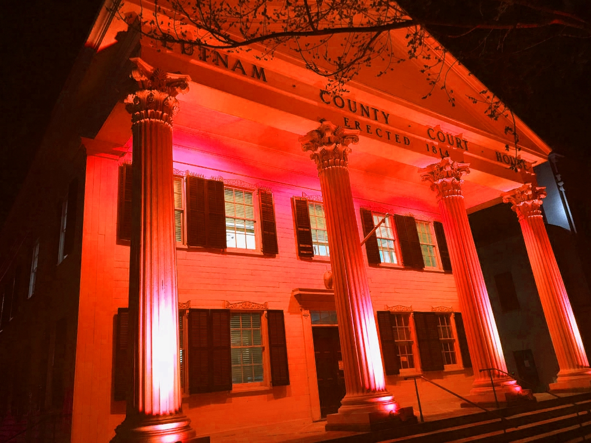 The historic courthouse in Carmel, New York, is lit in red this week to honor the memory of a firefighter from the Rockaways killed in Brooklyn.