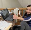 This ICGS second grade student completes her reading homework, with the help of her computer, at home on March 17th.