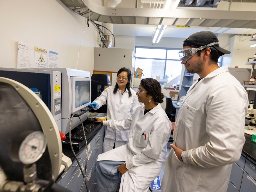 Professor Yangyang Liu, left, working with Cal State LA chemistry students in her research lab. 