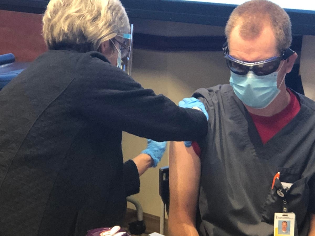 John Haacke, RN, critical care nurse at UM Upper Chesapeake Medical Center, receives the COVID-19 Pfizer vaccine from Deborah Crivello, RN.