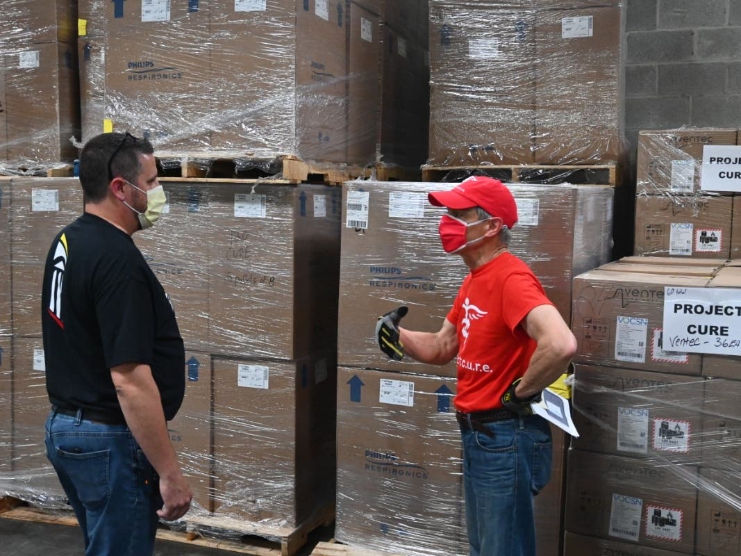 Jason Fraker, manager of the University of Maryland Medical System warehouse, and Project C.U.R.E. volunteer driver Larry Colletta check the pallets in the warehouse.
