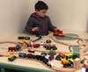 Interactive learning stations include a large wooden train table for kids.