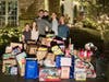 The Younge family (left to right) Braedon, Avery, dad Bryan, pediatric cancer patient Hudson Younge, Evan and mom Shelby in front of their Lakewood home overlooking the enormous donation of toys. 