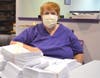 Rita Parsons pauses next to a stack of envelopes prepared for our next newsletter mailing.