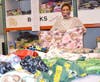 Orland Park resident Barb Ramsingh (right) proudly displays her hand-crafted comfort blankets at the Treasure Chest Foundation’s Orland Park warehouse. 