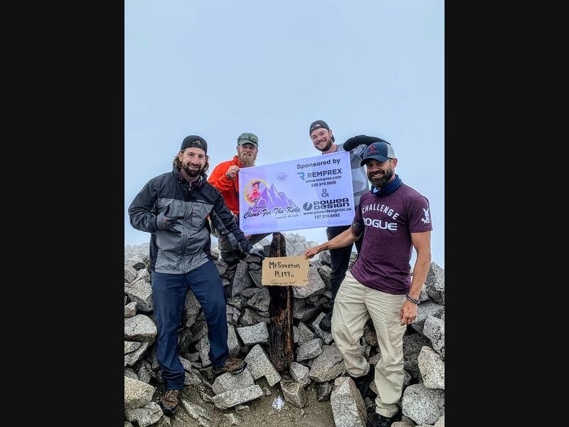 (left to right): Nick Andrejko, Steve Jackson, Martin Kisel and Oak Forest resident Jim Felgenhauer display their ‘Climb for the Kids’ signage at the top of Mt. Princeton. Thanks to their tireless efforts, the foursome raised an amazing $5,460.
