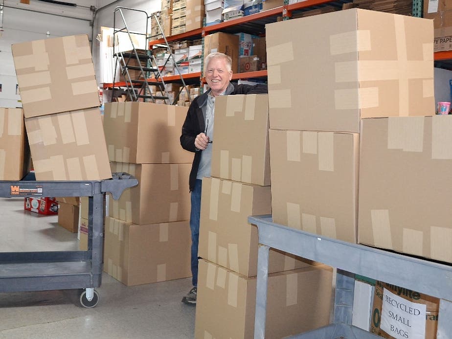 Mount Greenwood resident Dan Ritchie pauses next to 12, boxes of toys he has prepared for shipping to young cancer patients on behalf of the Treasure Chest Foundation. His volunteer efforts will bring smiles of comfort and joy to thousands of children.
