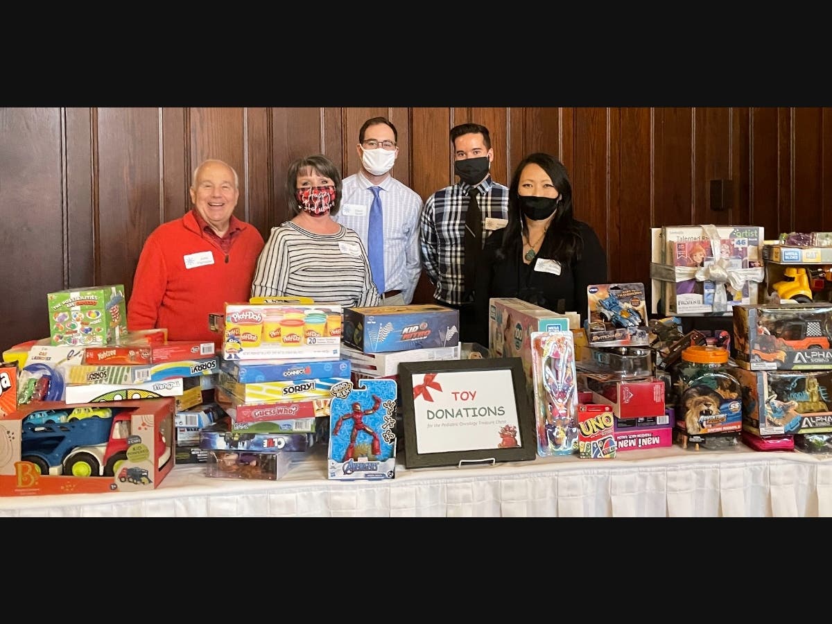 Five Goodheart-Willcox employees display some of the donated toys collected during the Goodheart-Willcox holiday party at Olympia Fields Country Club. 