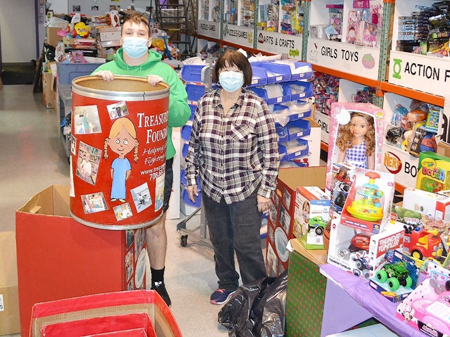 Homer Glen resident Derek Murray (age 15) and grandmother, Diana Karasek packaging toys for kids with cancer while emptying toy collection bins to help during the busy holiday season at the Treasure Chest Foundation’s Orland Park warehouse. 