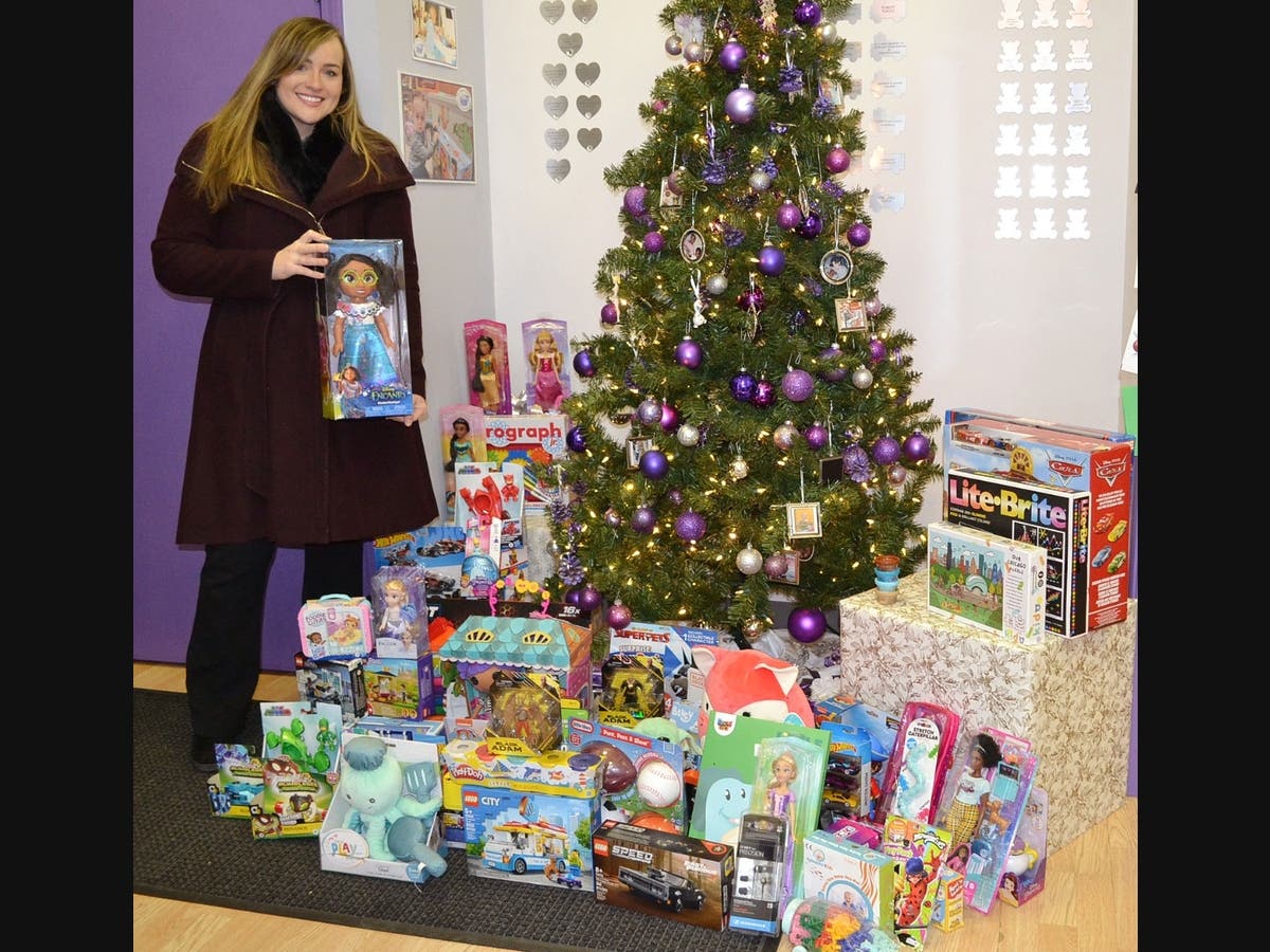 Vice President of Property Management Kelsey Byrne and toy deliverer displays some of the donated toys at the Treasure Chest Foundation facility in Orland Park.