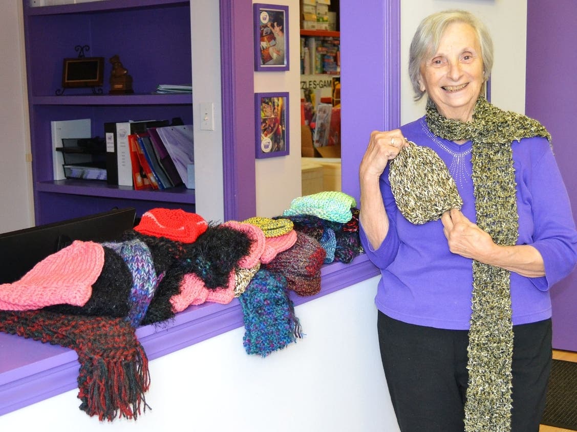 Indian Head Park Women’s Club Second Vice President and head recruiter Marge Nelson displaying some of the knitted hats and scarves at the Treasure Chest Foundation’s Orland Park warehouse.