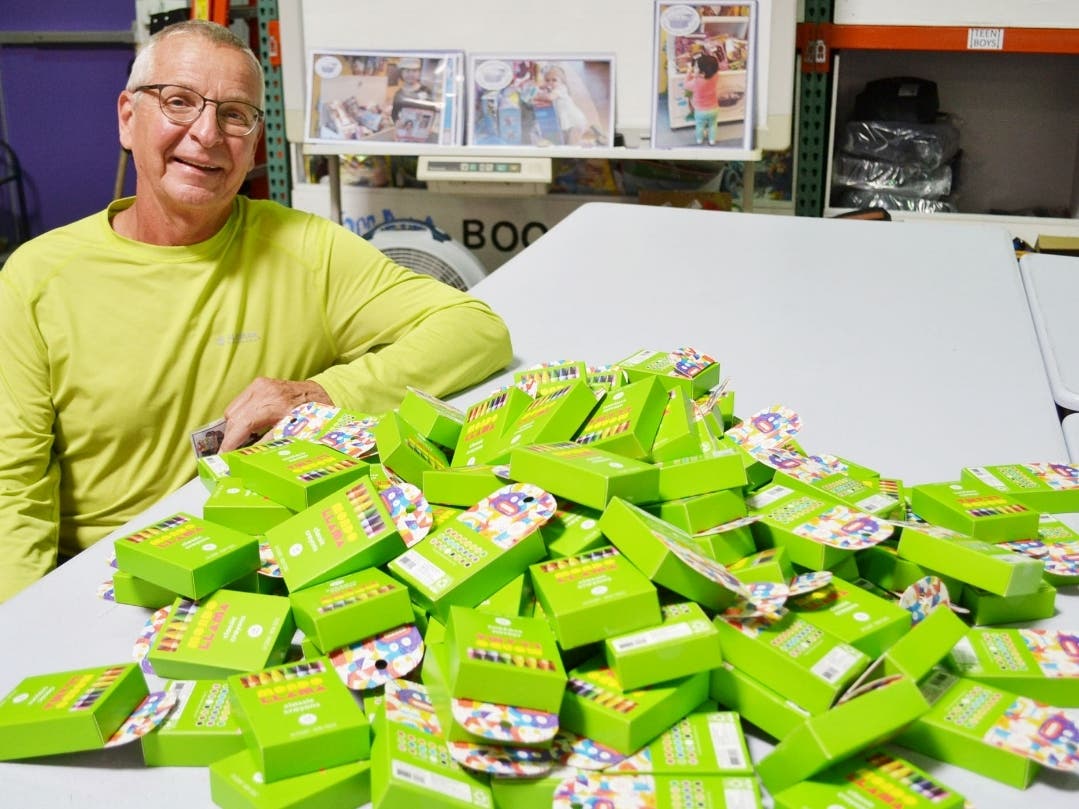 Highland Park resident Stephen Hawrysz displaying some of the crayons at the Treasure Chest Foundation’s Orland Park warehouse.