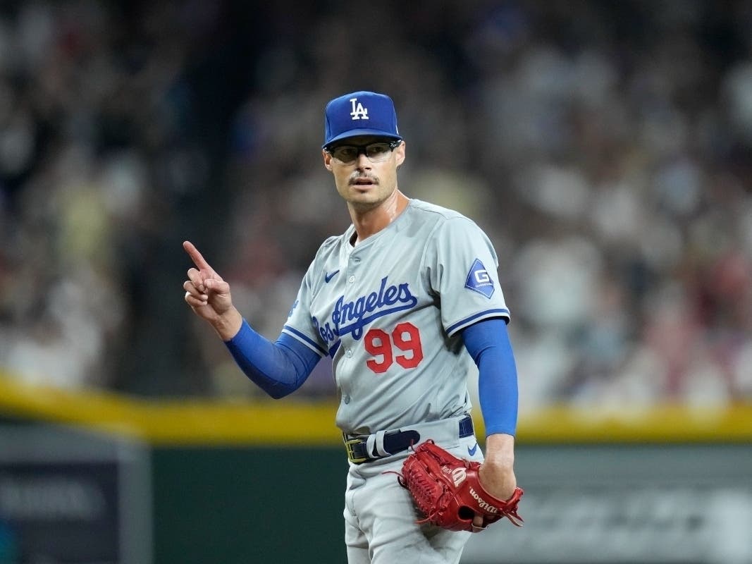 Los Angeles Dodgers relief pitcher Joe Kelly signals to the bench after being called for too many pickoff throws to first base during the third inning of a baseball game against the Arizona Diamondbacks Friday, Aug. 30, 2024, in Phoenix. 